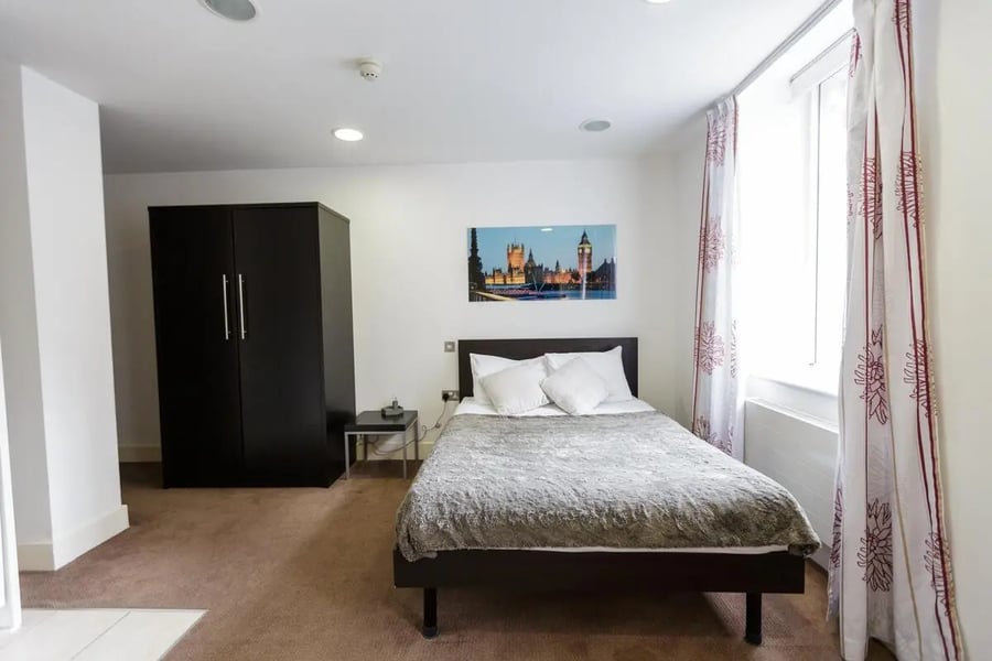 Bed wardrobe artwork and curtains bedroom at AXO Oxford Circus in London Student Accommodation