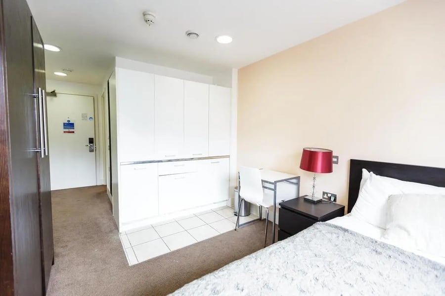 Closet bed desk lamp white cabinets bedroom at AXO Oxford Circus in London Student Accommodation
