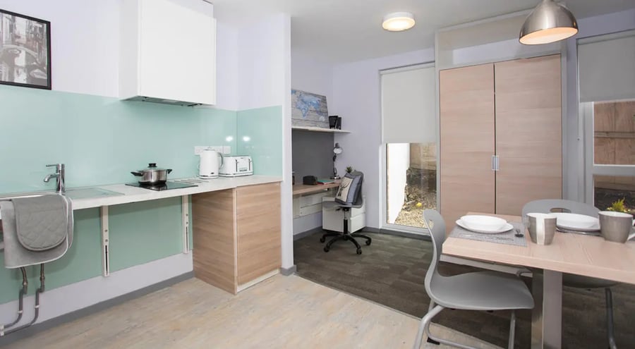 Kitchen sink stove toaster desk chairs dining table kitchen at Duresme Court in Durham Student Accommodation