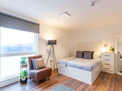 Bed with grey pillows and side table Bedroom at Harbour Court in Bristol Student Accommodation