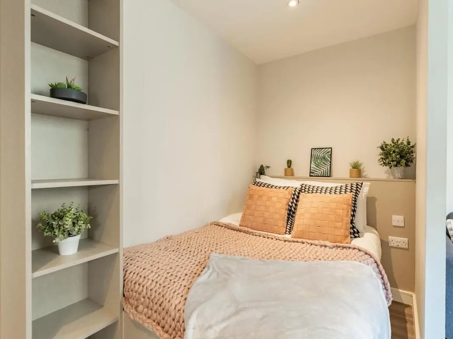 Bed with plants and bookshelves bedroom at Redvers Tower in Sheffield Student Accommodation