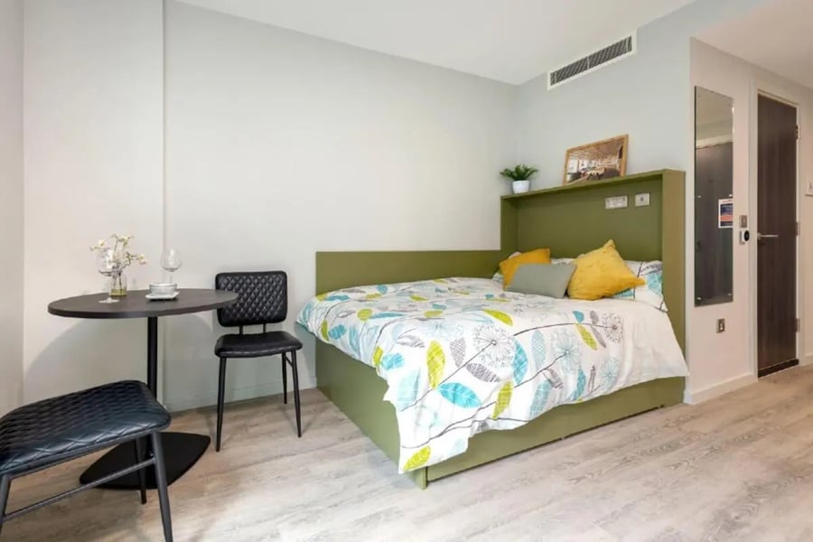Bed table chairs and desk bedroom at Flora Building - Hoxton in London Student Accommodation