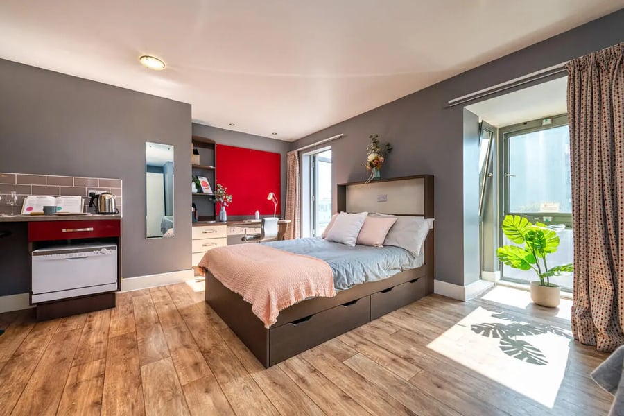 Bed desk dishwasher kitchen mirror bedroom area at Collegiate Dashwood Studios in London Student Accommodation