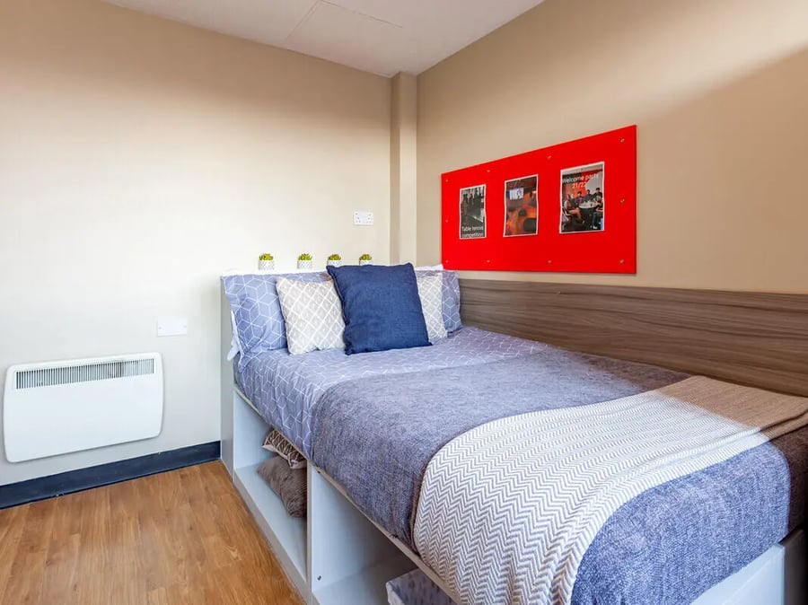 Bed with patterned bedding and photos on wall bedroom at Ben Russell Court in Leicester Student Accommodation