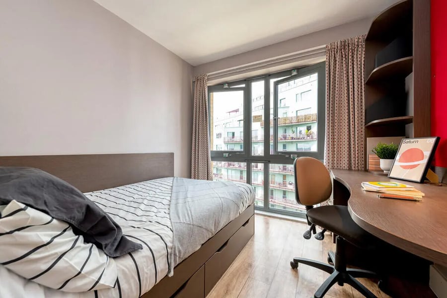 Bed desk chair and window view student bedroom at Collegiate Dashwood Studios in London Student Accommodation
