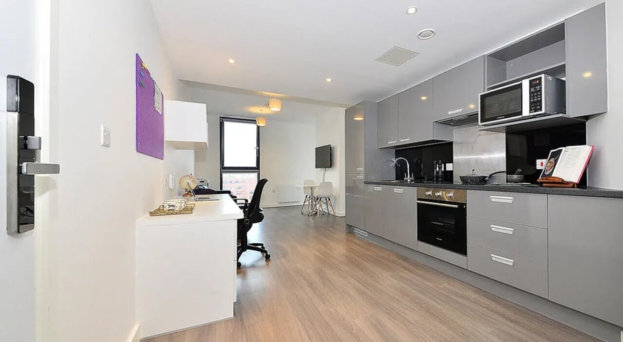 Desk microwave oven and cabinets kitchen living area at 88 Bromsgrove House in Birmingham Student Accommodation
