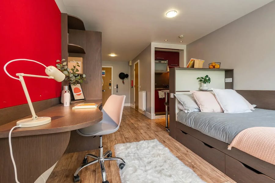 Desk bed rug kitchen area studio apartment at Collegiate Dashwood Studios in London Student Accommodation