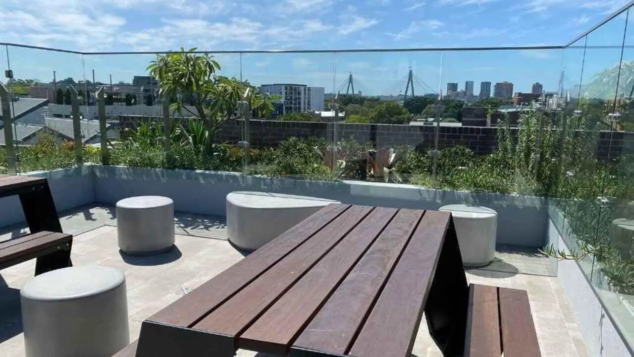 Outdoor seating area with picnic table and stools exterior at UniLodge Ultimo in Sydney Student Accommodation