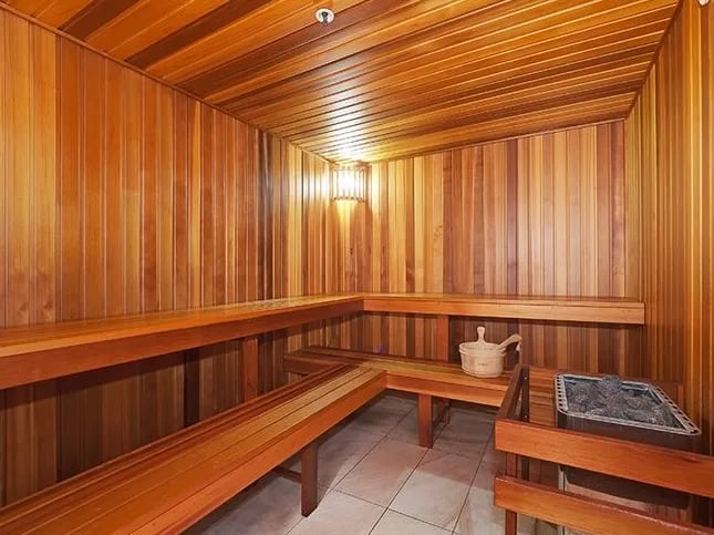 Wooden sauna benches bucket and heater sauna at Belong Mascot in Sydney Student Accommodation