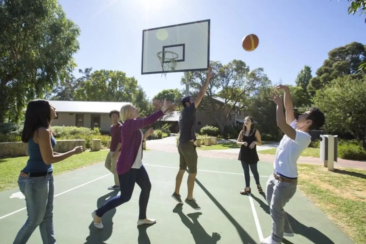 Students play basketball on a court outdoor playing area at ECU Villlage Mount Lawley in Perth Student Accommodation