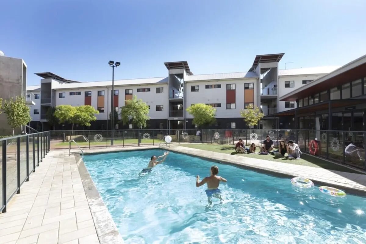 People swimming and relaxing by the pool outdoor area at ECU Villlage Mount Lawley in Perth Student Accommodation