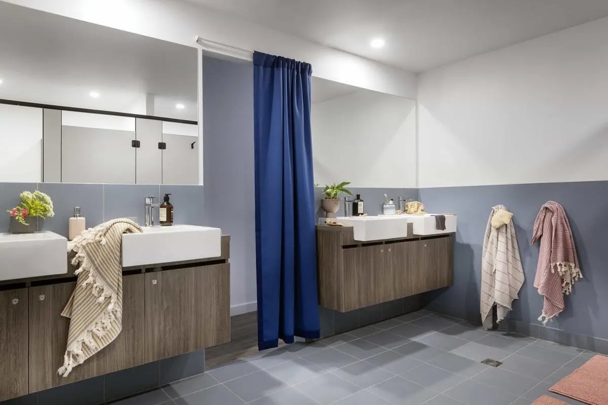 Double sinks with towels and blue curtain bathroom at Campus Perth in Perth Student Accommodation