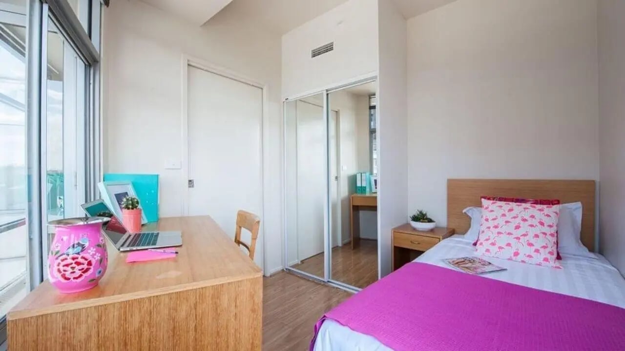 Desk laptop bed and closet bedroom at Student Living - 570 Swanston in Melbourne Student Accommodation