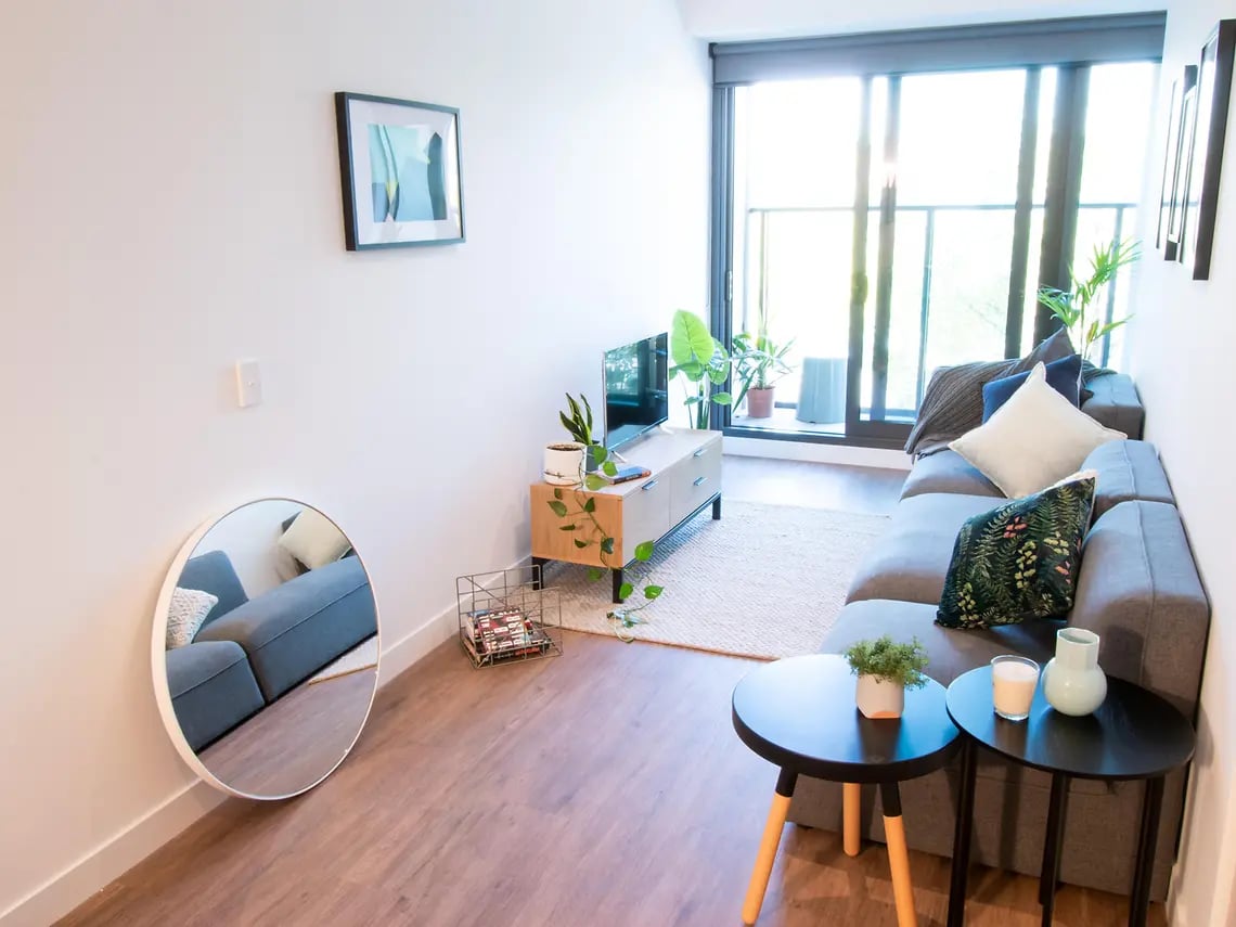 Sofa television round mirror coffee tables living room at Yugo Berkeley Street in Melbourne Student Accommodation