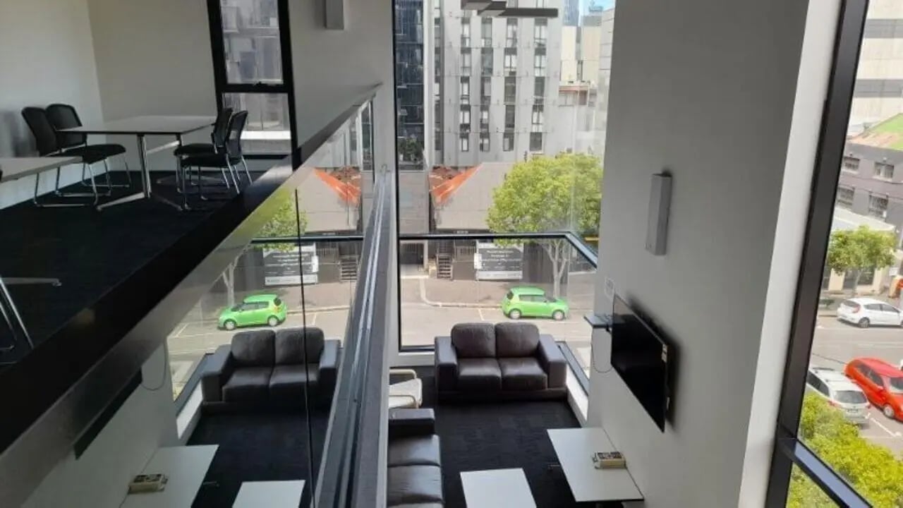 Table chairs sofas TV living area at Student Living on Villiers in Melbourne Student Accommodation