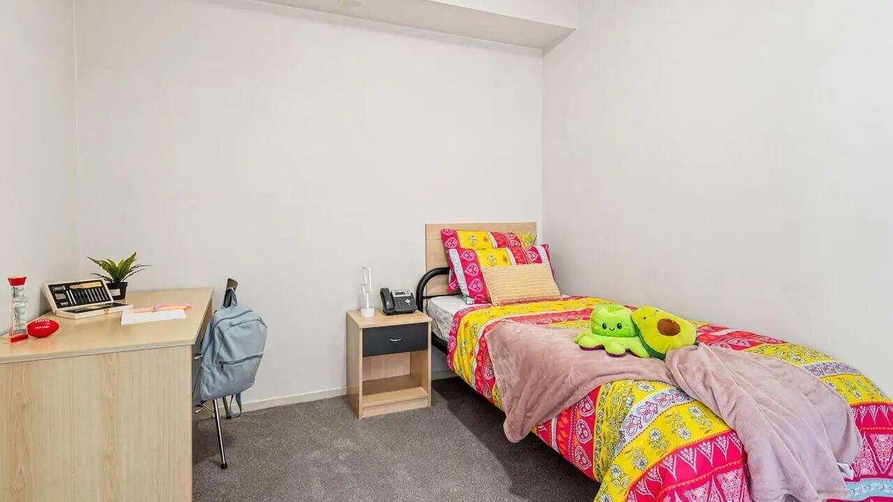 Bed desk backpack phone nightstand bedroom at Student Living on Lonsdale in Melbourne Student Accommodation