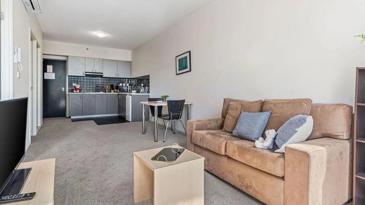 Sofa kitchen table and TV living area at Student Living on Lonsdale in Melbourne Student Accommodation