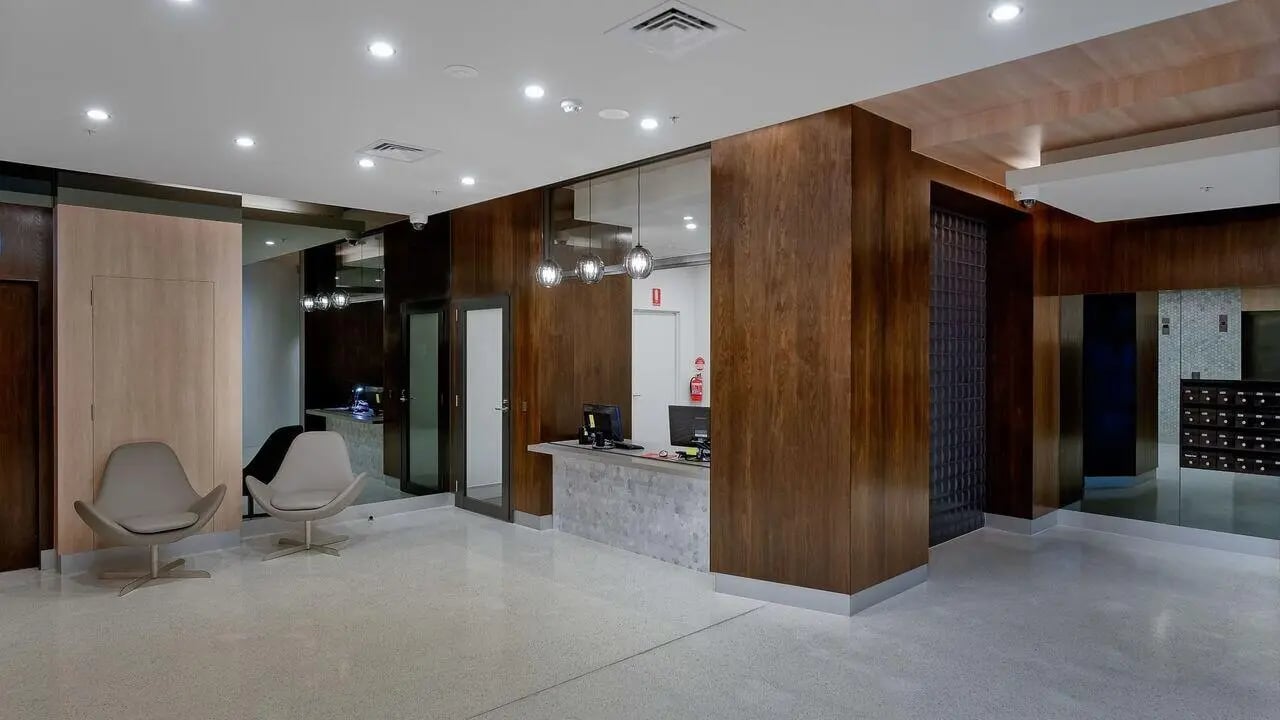 Chairs reception desk computers and mailboxes lobby at Student Living on Lonsdale in Melbourne Student Accommodation