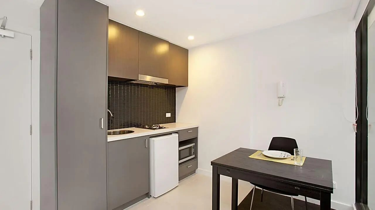Compact kitchen with table and chairs kitchen at Student Living on Raleigh in Melbourne Student Accommodation