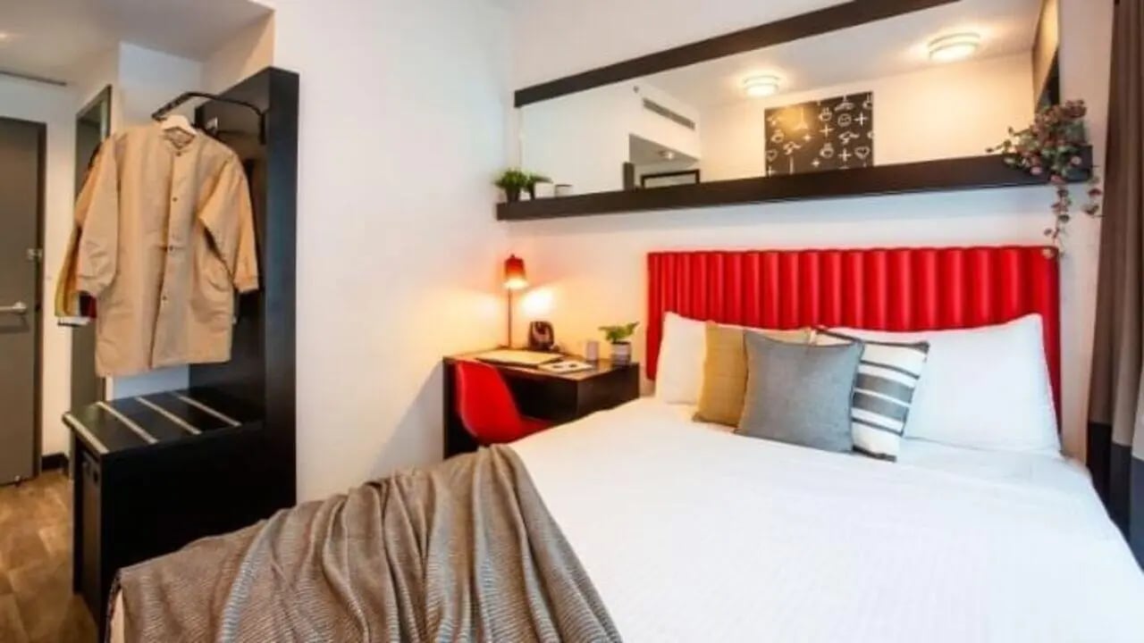 Bed desk lamp chair and closet bedroom at UniLodge Carlton in Melbourne Student Accommodation