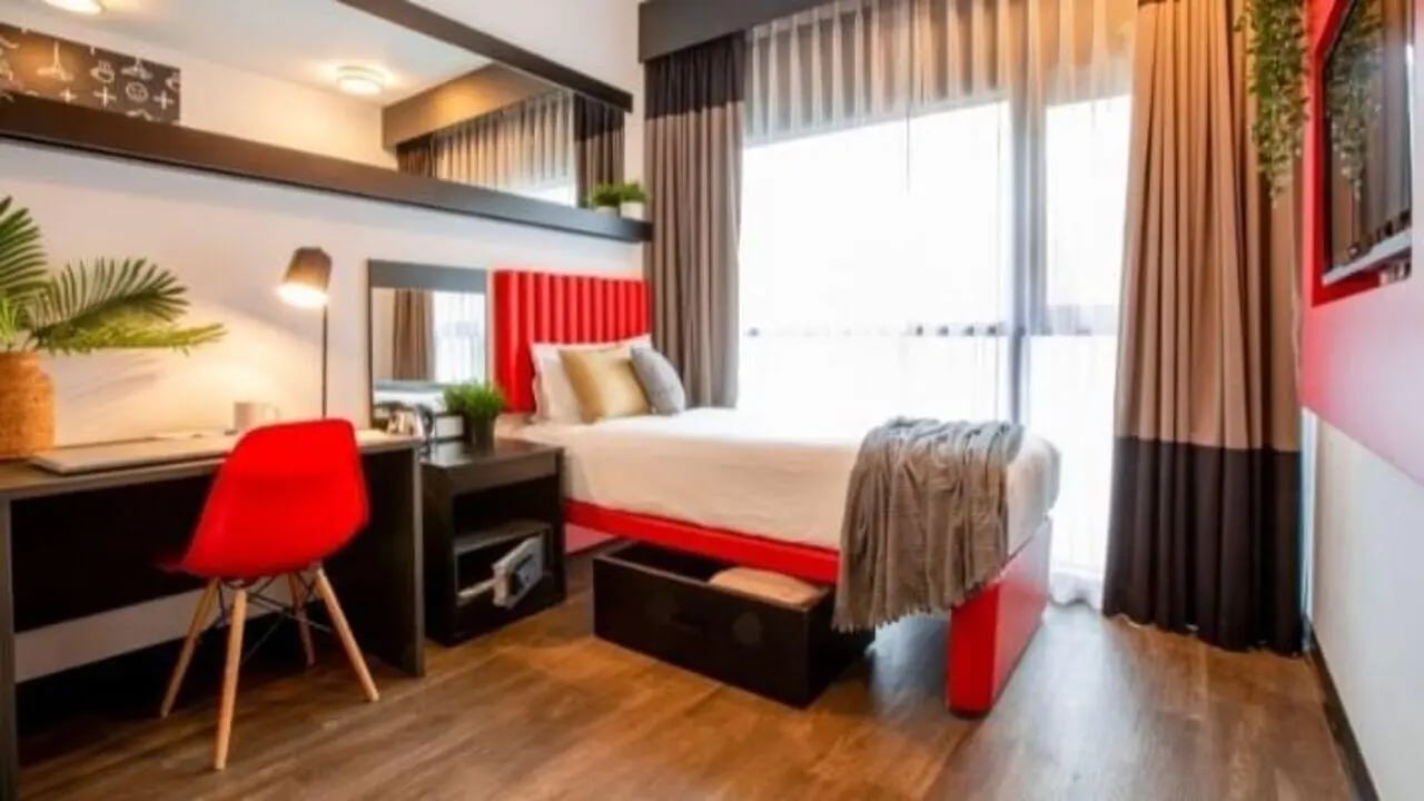 Bed desk red chair mirror bedroom at UniLodge Carlton in Melbourne Student Accommodation