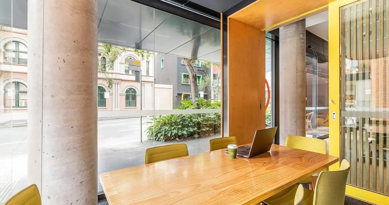 Table with laptop and chairs study area at Iglu Central in Sydney Student Accommodation