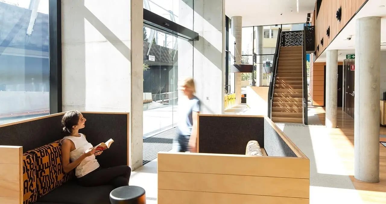 Modern seating area with woman reading living room at Iglu Chatswood in Sydney Student Accommodation