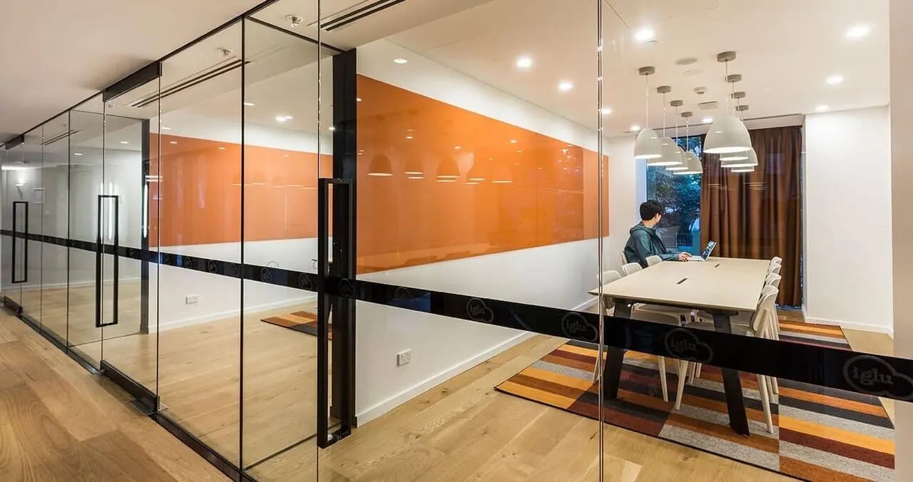 Meeting room with table chairs and person working Computer at Iglu Chatswood in Sydney Student Accommodation
