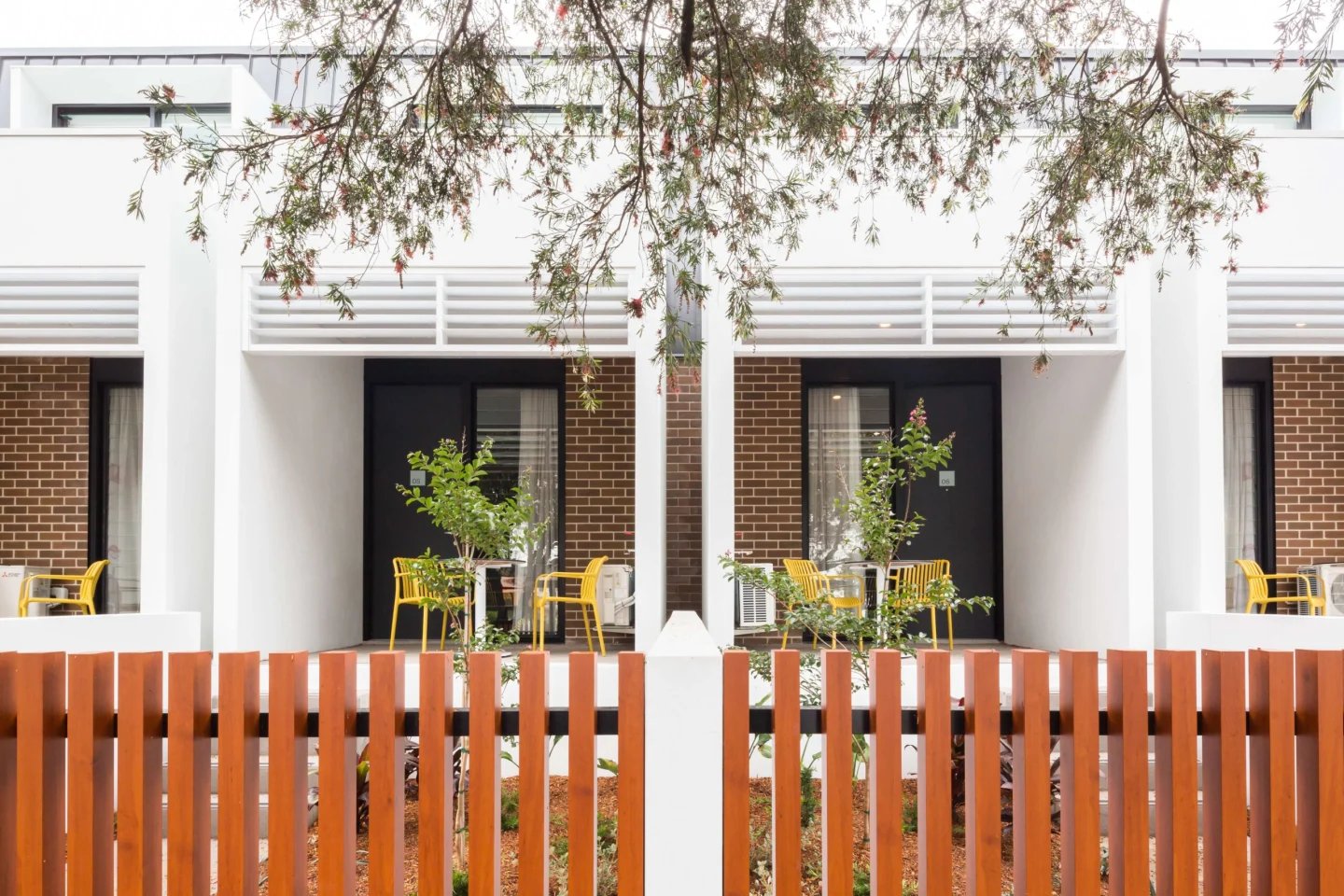 Yellow chairs and tables on paved patio exterior at UKO Marrickville Village in Sydney Student Accommodation