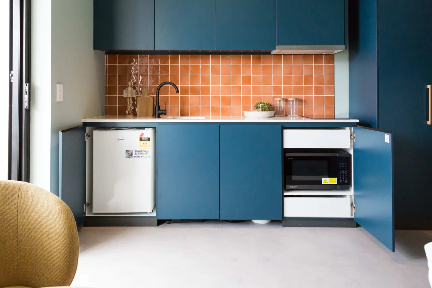 Small fridge microwave sink terracotta tiled kitchen at UKO Marrickville Village in Sydney Student Accommodation