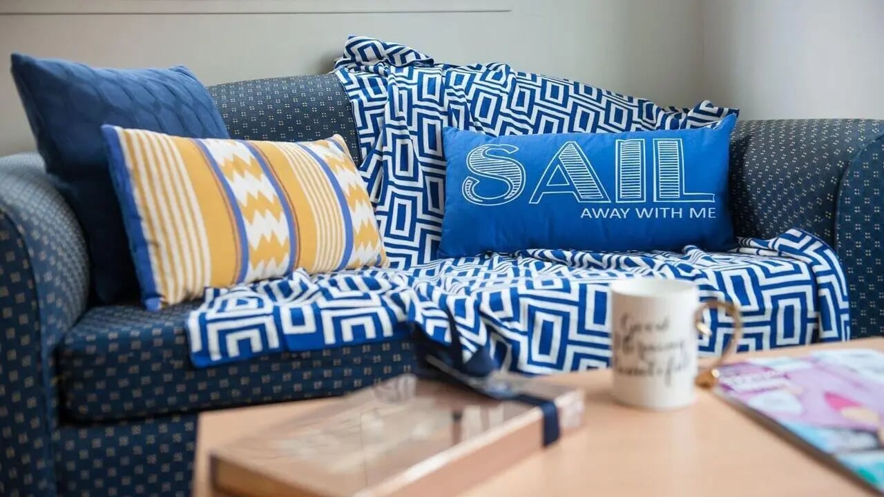 Blue sofa with patterned throw and pillows living room at Student Living-339 Swanston in Melbourne Student Accommodation