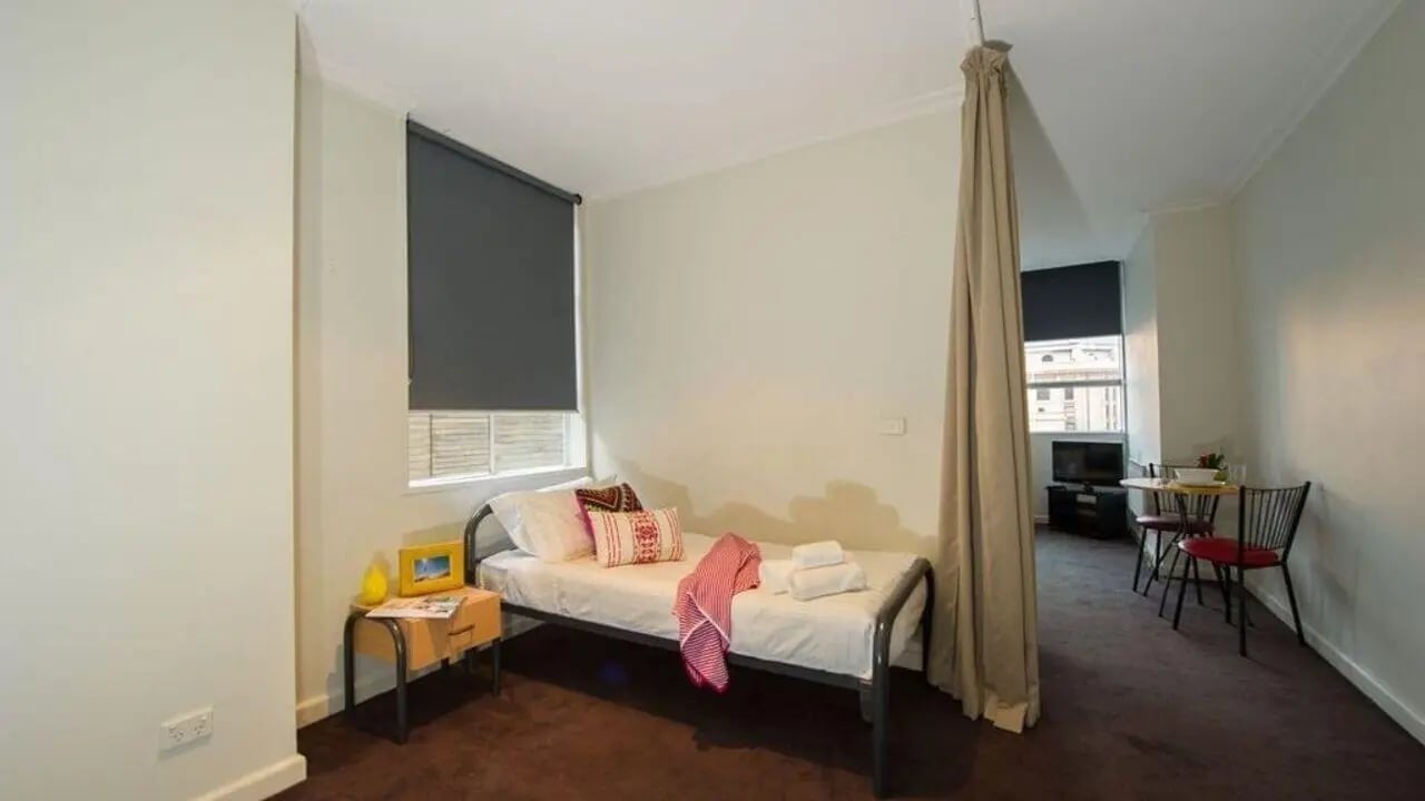 Bed side table and neatly made bed bedroom at Student Living-339 Swanston in Melbourne Student Accommodation