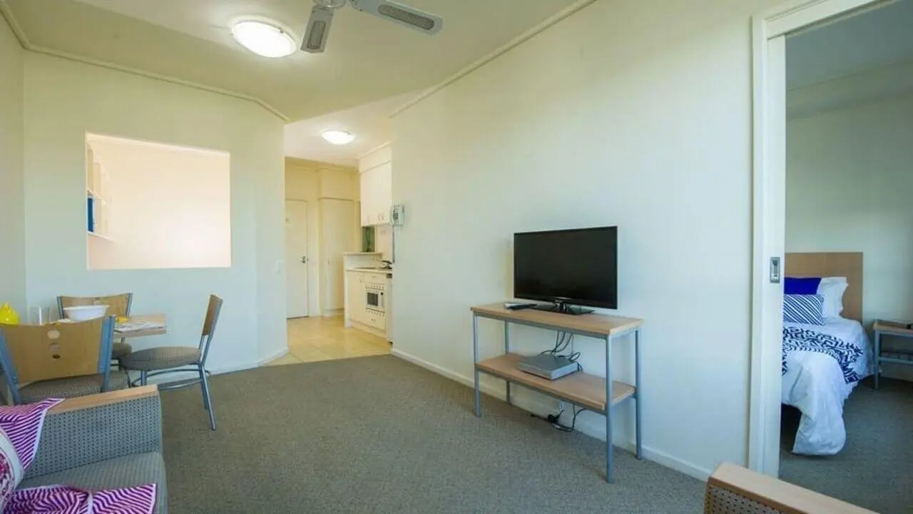 Living room with TV dining table and bedroom exterior at Student Living - 570 Lygon in Melbourne Student Accommodation