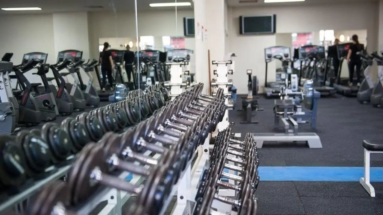 Dumbbell racks treadmills and weight machines gym interior at Student Living - 570 Lygon in Melbourne Student Accommodation