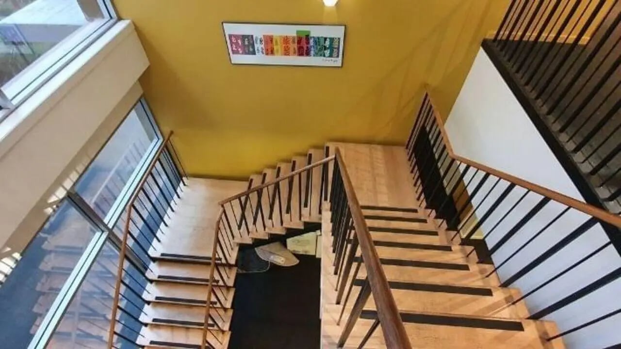 Wooden staircase with black railings and artwork Interior at Student Living - 570 Lygon in Melbourne Student Accommodation
