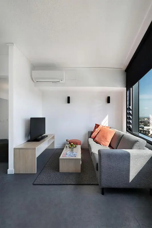 Sofa coffee table television air conditioner living room at Iglu Melbourne City in Melbourne Student Accommodation