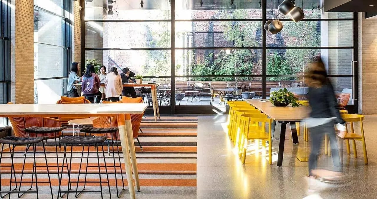 Students sit at tables in a communal lounge area at Iglu Melbourne City in Melbourne Student Accommodation