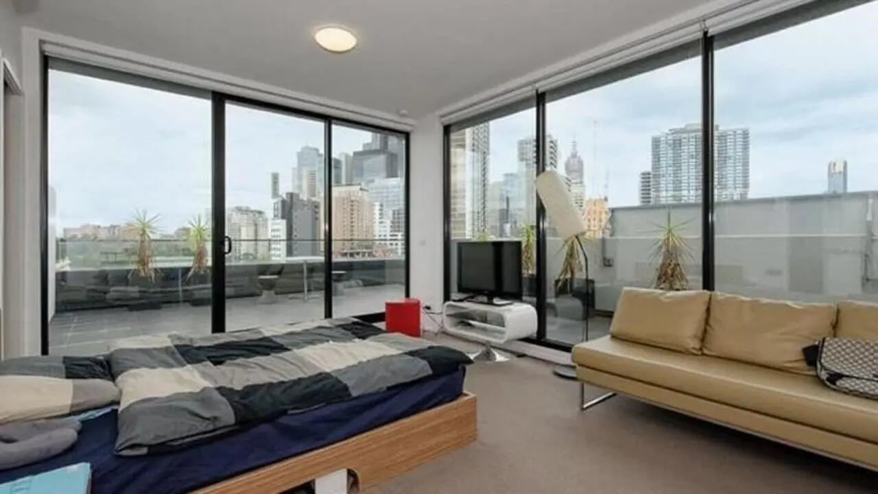 Bed sofa television balcony city view bedroom living room at Student Living D2 in Melbourne Student Accommodation