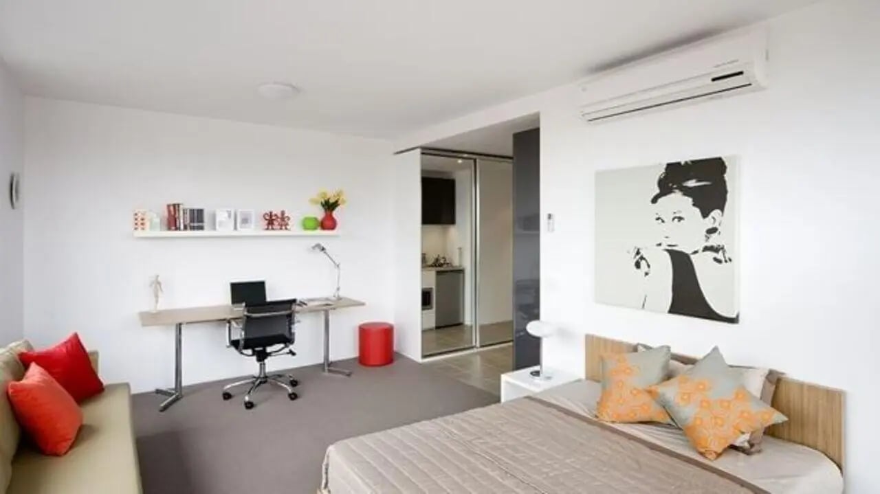 Bed desk couch artwork and kitchen area studio at Student Living D2 in Melbourne Student Accommodation