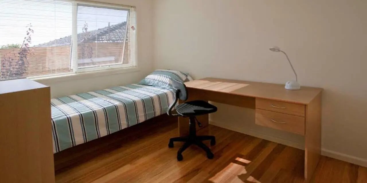 Bed desk chair lamp wooden floor bedroom at Sunset House in Melbourne Student Accommodation