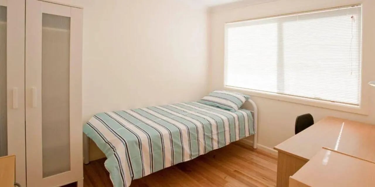 White wardrobe single bed desk chair bedroom at Sunset House in Melbourne Student Accommodation