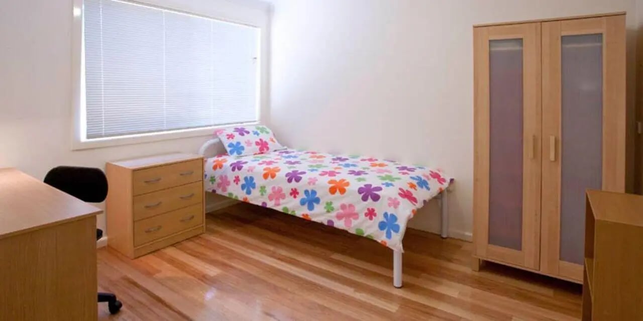 Bed dresser wardrobe desk and chair bedroom at Sunset House in Melbourne Student Accommodation