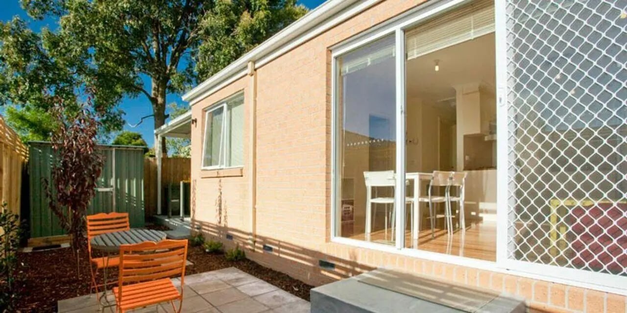 Orange chairs table outdoor kitchen exterior at Sunset House in Melbourne Student Accommodation