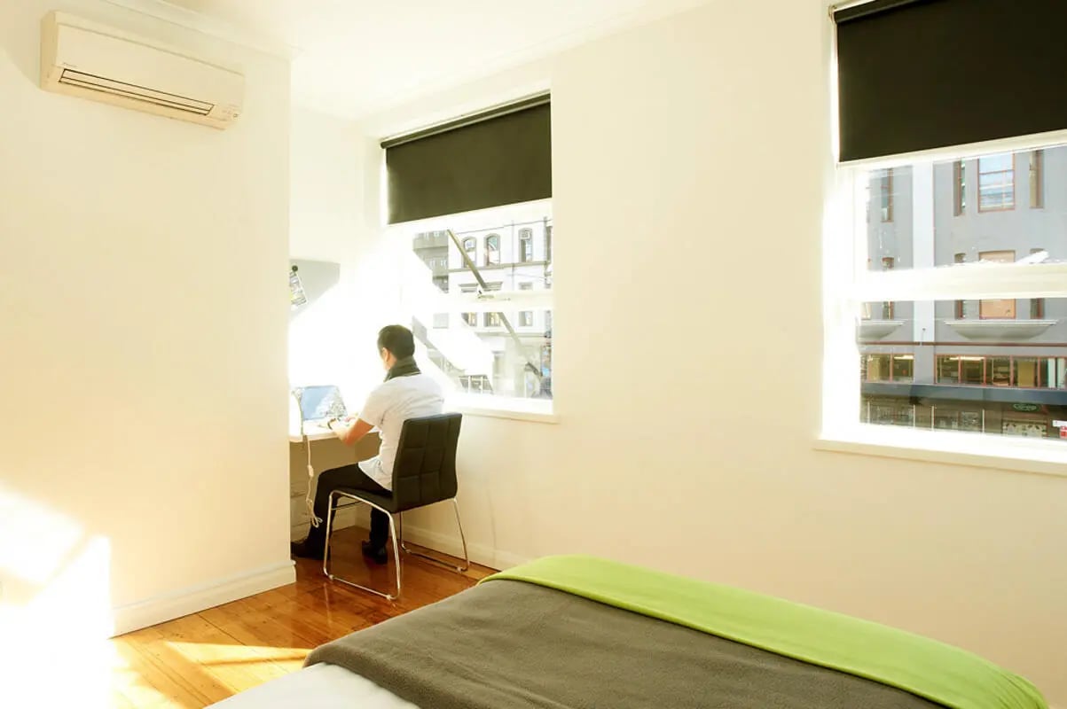 Desk chair laptop person by window study area at Link2 Broadway in Sydney Student Accommodation