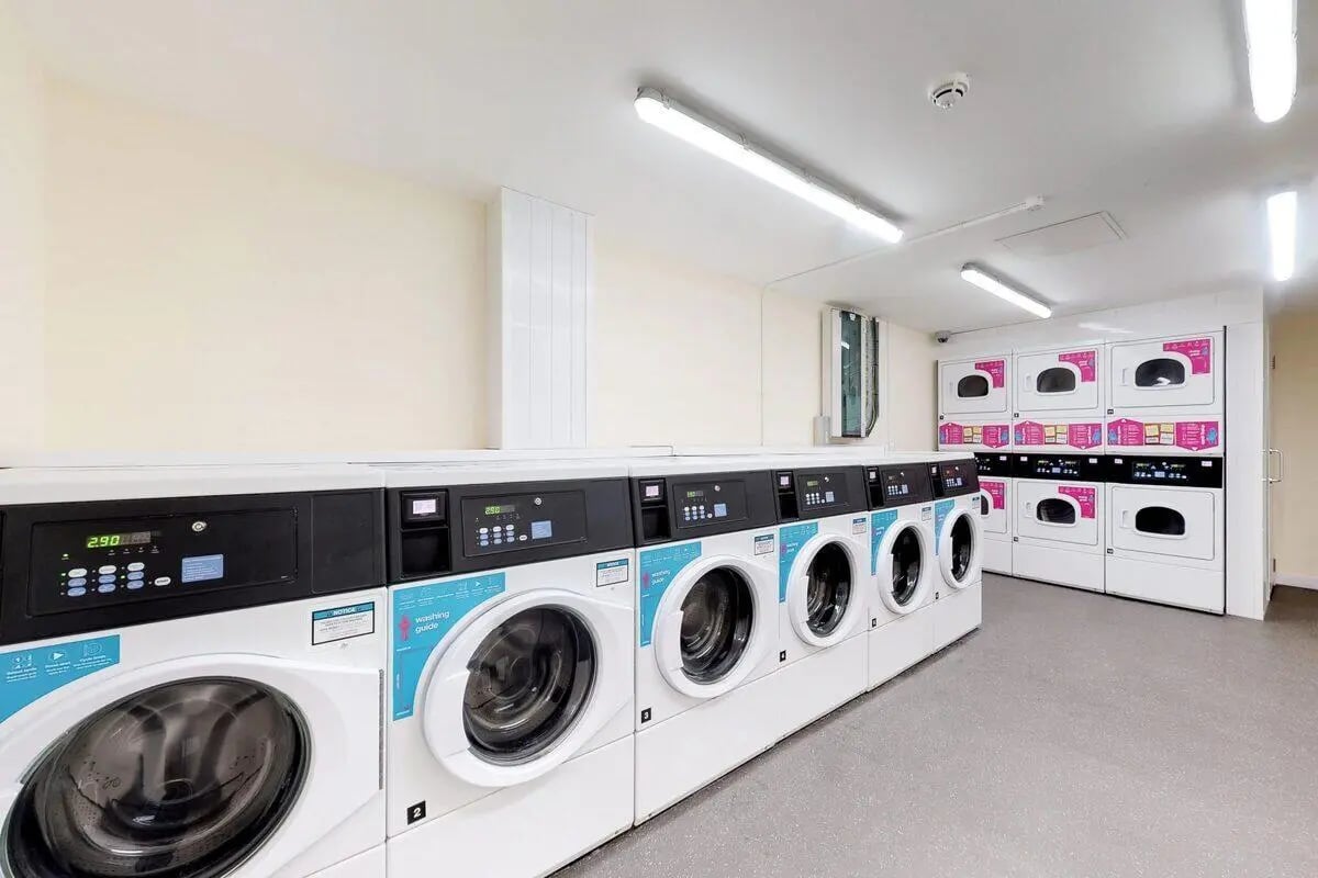 Row of washing machines and dryers laundry room at St James Glasgow in Glasgow Student Accommodation