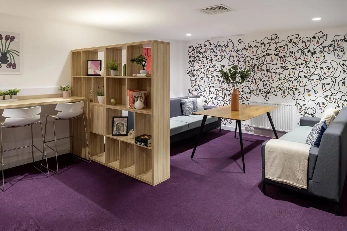 Bookshelves sofas table and stools living area at St James Glasgow in Glasgow Student Accommodation