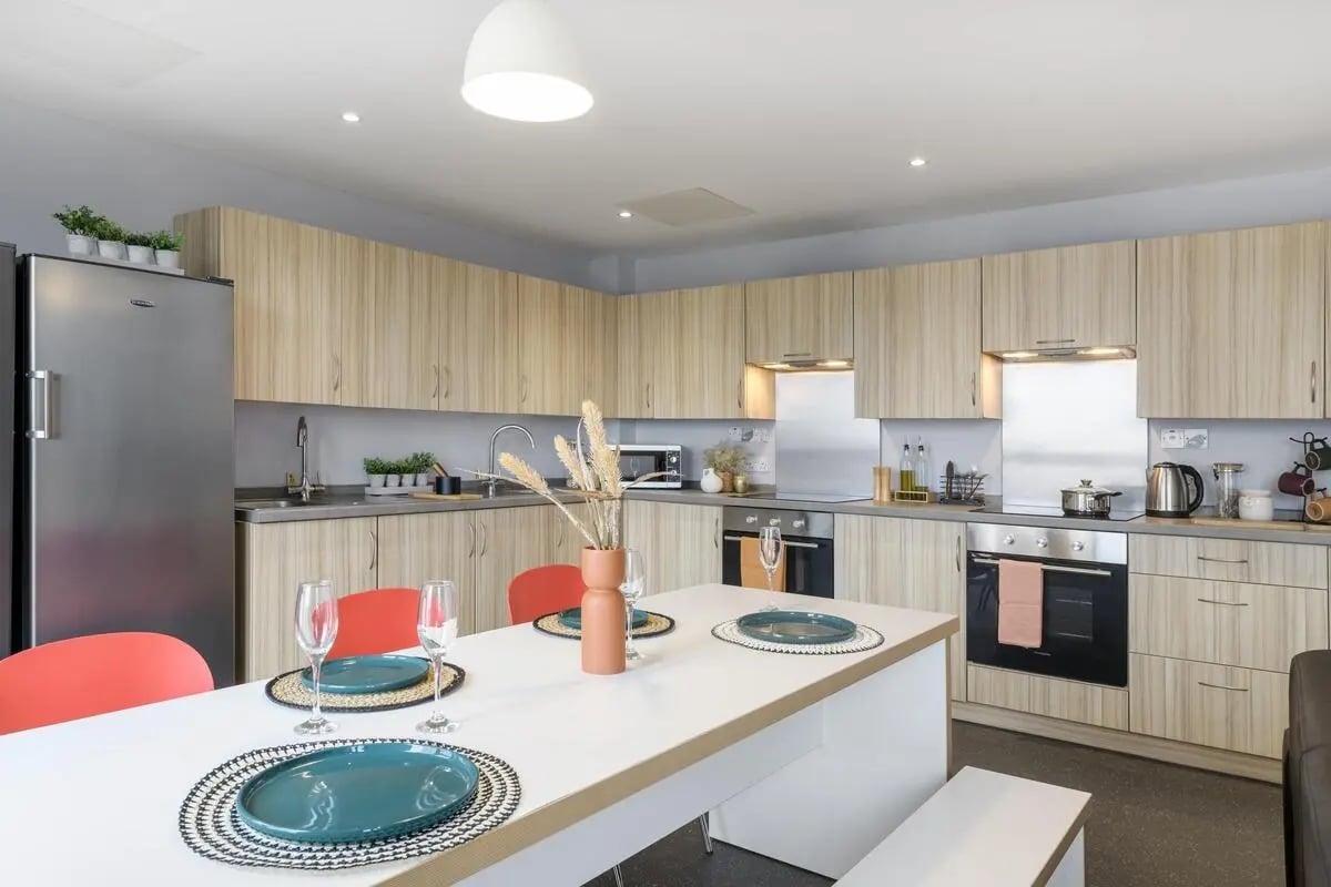 Kitchen with dining table refrigerator and cabinets Kitchen at St James Glasgow in Glasgow Student Accommodation