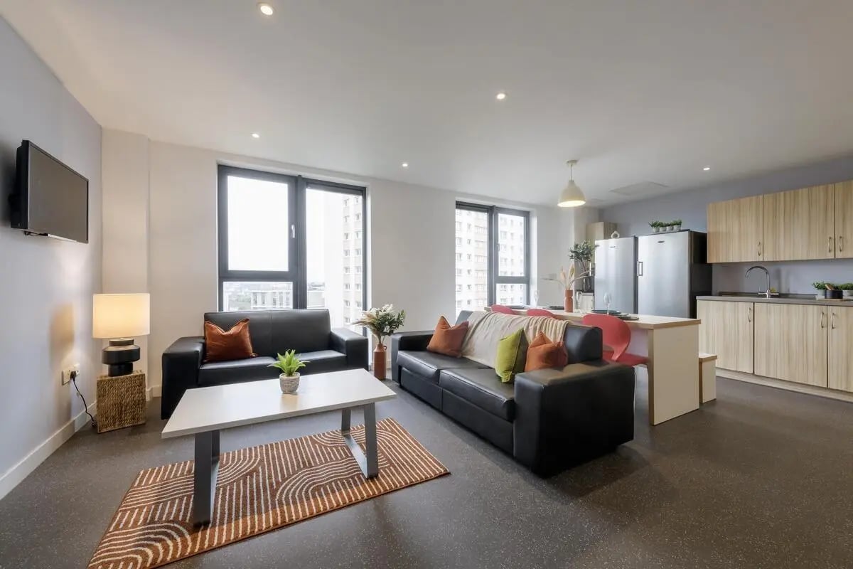 Living room with sofas kitchen and appliances living room at St James Glasgow in Glasgow Student Accommodation