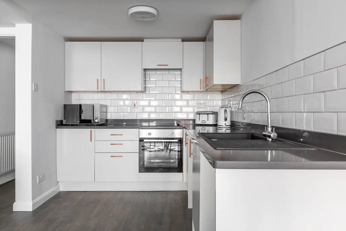 White cabinets microwave oven sink kitchen at Hyde Park in Leeds Student Accommodation