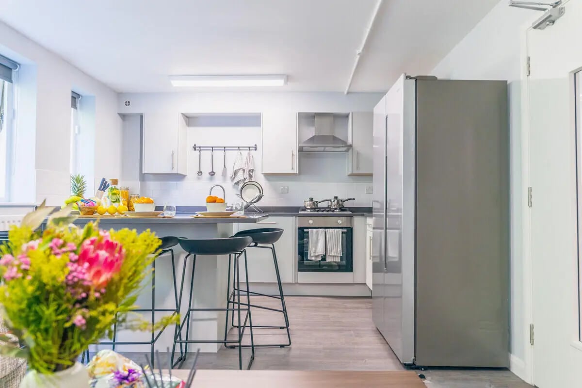 Kitchen with bar stools fridge and oven kitchen at Beech Gardens in Birmingham Student Accommodation